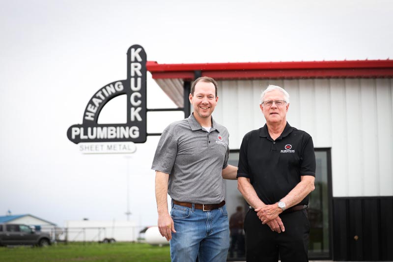 Owners of Kruck Plumbing & Heating standing outside of their business